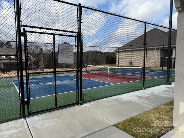 view of sport court featuring a gate and fence