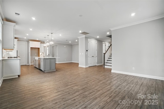 9657 Liberty Hill Dr, Mint Hill, NC 28227 - unfurnished living room featuring recessed lighting, ornamental molding, baseboards, wood finished floors, and a sink