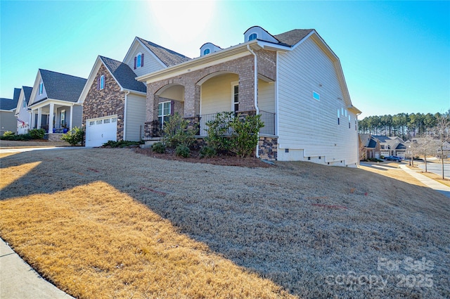 view of front of property featuring a garage, a front lawn, and a porch