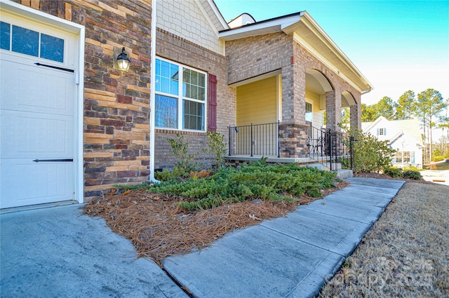 property entrance with covered porch and a garage