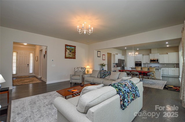 living room with sink, dark hardwood / wood-style floors, and an inviting chandelier