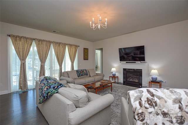 living room with dark hardwood / wood-style floors and an inviting chandelier