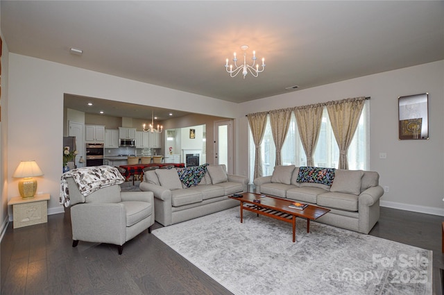 living room with dark hardwood / wood-style flooring and an inviting chandelier