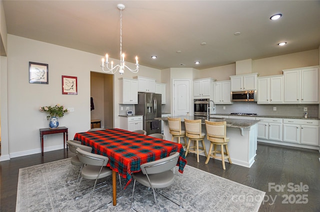 dining space with an inviting chandelier, dark hardwood / wood-style flooring, and sink