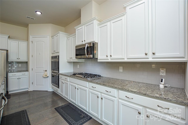 kitchen featuring white cabinets, decorative backsplash, light stone countertops, and stainless steel appliances