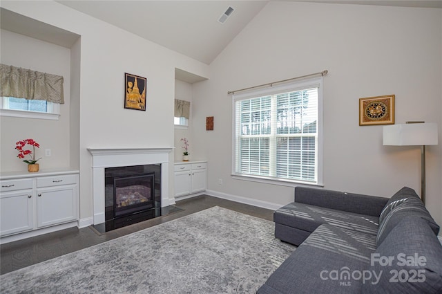 living room featuring dark wood-type flooring and high vaulted ceiling