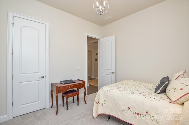 carpeted bedroom with a notable chandelier