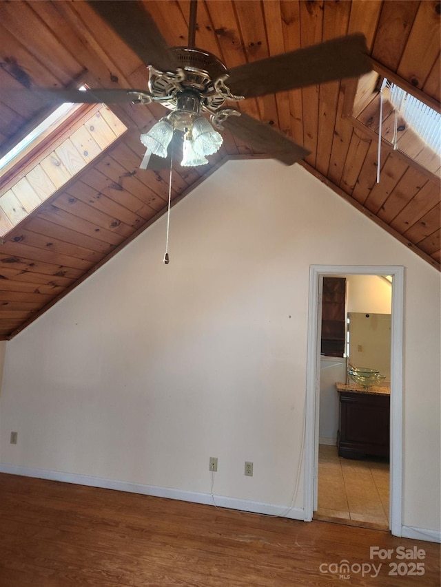 bonus room with wood ceiling, light hardwood / wood-style flooring, lofted ceiling with skylight, and ceiling fan