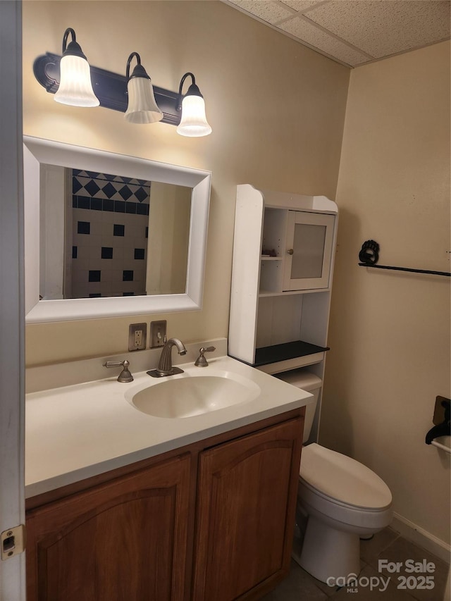 bathroom featuring vanity, a paneled ceiling, and toilet