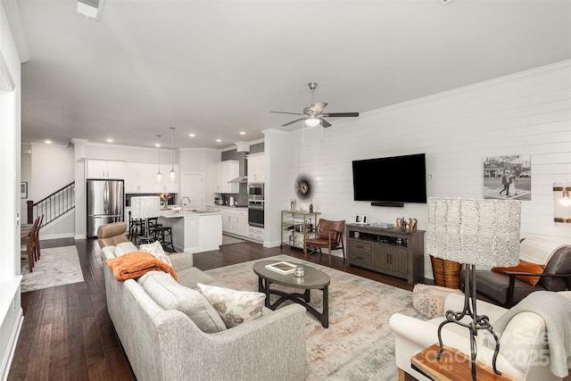 living room featuring ceiling fan, sink, dark hardwood / wood-style flooring, and ornamental molding