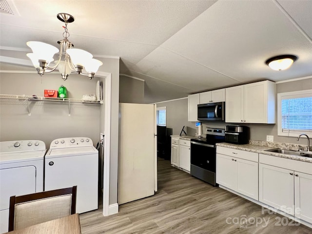 kitchen with independent washer and dryer, sink, hanging light fixtures, appliances with stainless steel finishes, and white cabinets