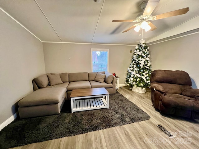 living room with ceiling fan, vaulted ceiling, and hardwood / wood-style floors