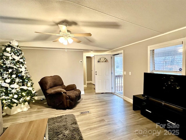 living room featuring ceiling fan, ornamental molding, and hardwood / wood-style flooring