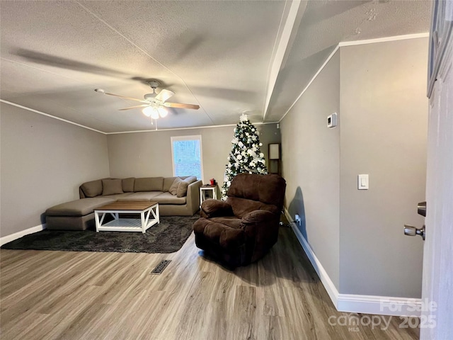 living room featuring ceiling fan, wood-type flooring, and a textured ceiling