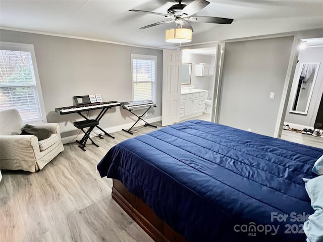 bedroom with ceiling fan, light hardwood / wood-style floors, crown molding, and ensuite bath