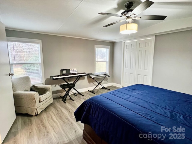 bedroom with ceiling fan, ornamental molding, a closet, and hardwood / wood-style floors