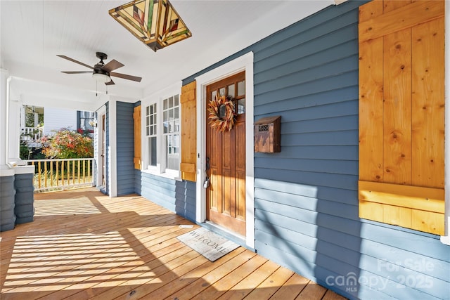 view of exterior entry with ceiling fan and covered porch