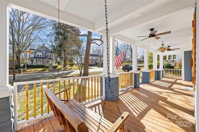 wooden terrace with ceiling fan and covered porch