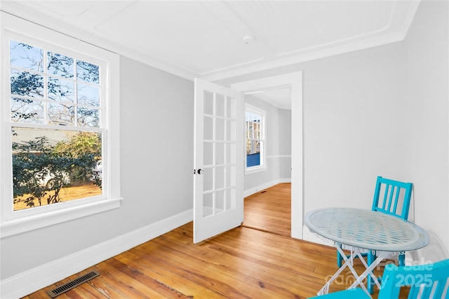 sitting room with hardwood / wood-style flooring, plenty of natural light, and crown molding