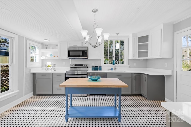 kitchen featuring gray cabinets, appliances with stainless steel finishes, pendant lighting, and sink