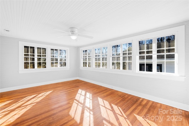 unfurnished sunroom with ceiling fan