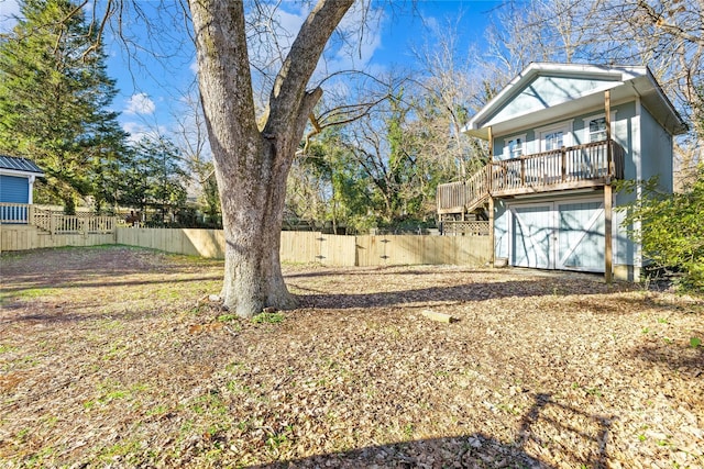 view of yard with a garage and a wooden deck