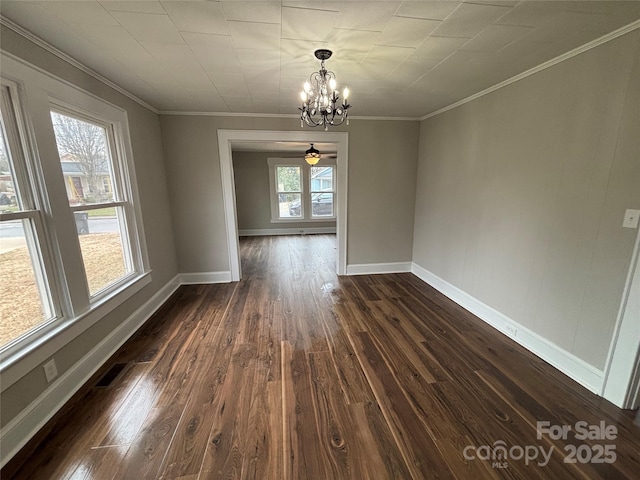 spare room featuring crown molding, dark hardwood / wood-style floors, and an inviting chandelier