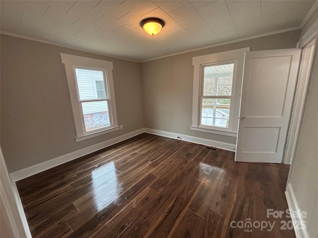 unfurnished room featuring crown molding, dark hardwood / wood-style floors, and a wealth of natural light