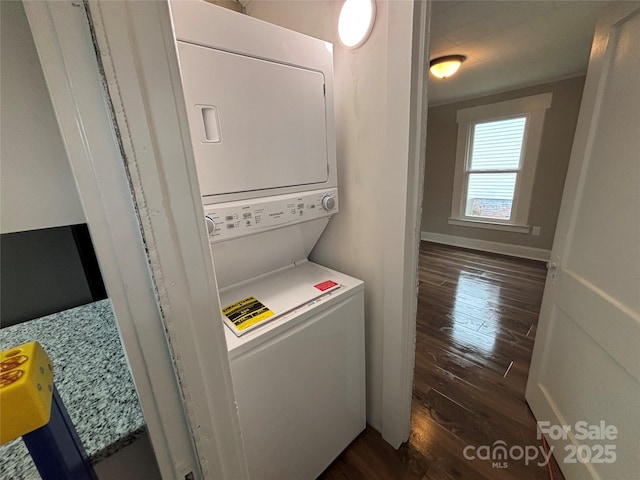 laundry area with dark hardwood / wood-style flooring and stacked washing maching and dryer