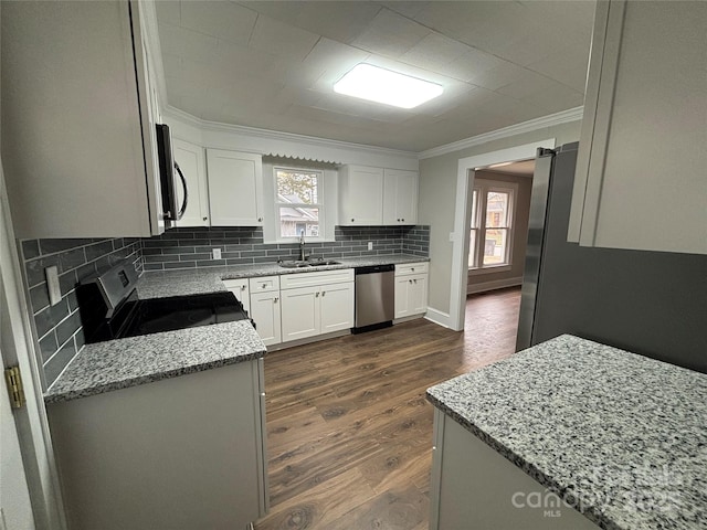 kitchen with sink, appliances with stainless steel finishes, white cabinets, and light stone counters