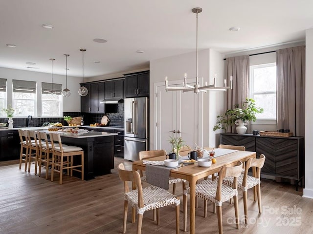 dining space featuring dark hardwood / wood-style floors, sink, and an inviting chandelier