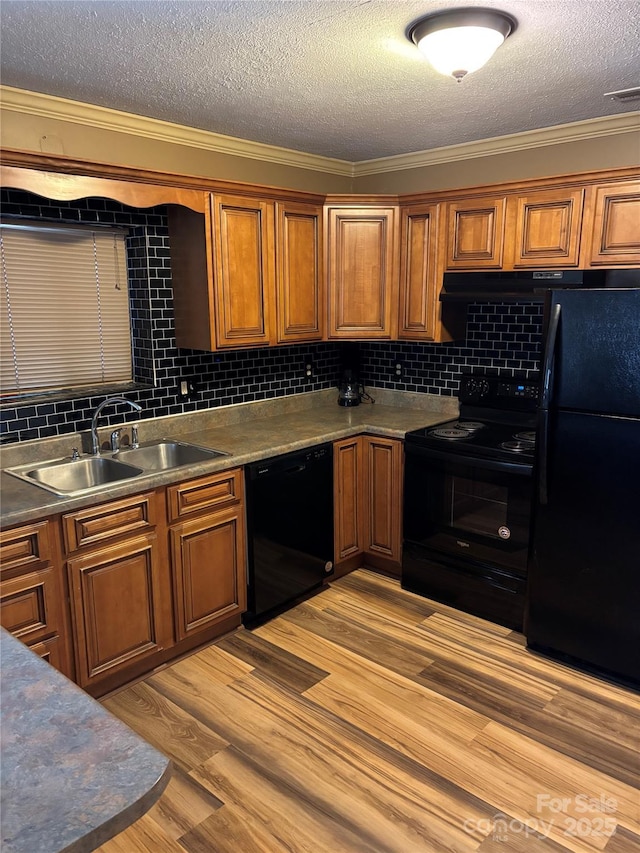 kitchen with black appliances, sink, a textured ceiling, and ornamental molding