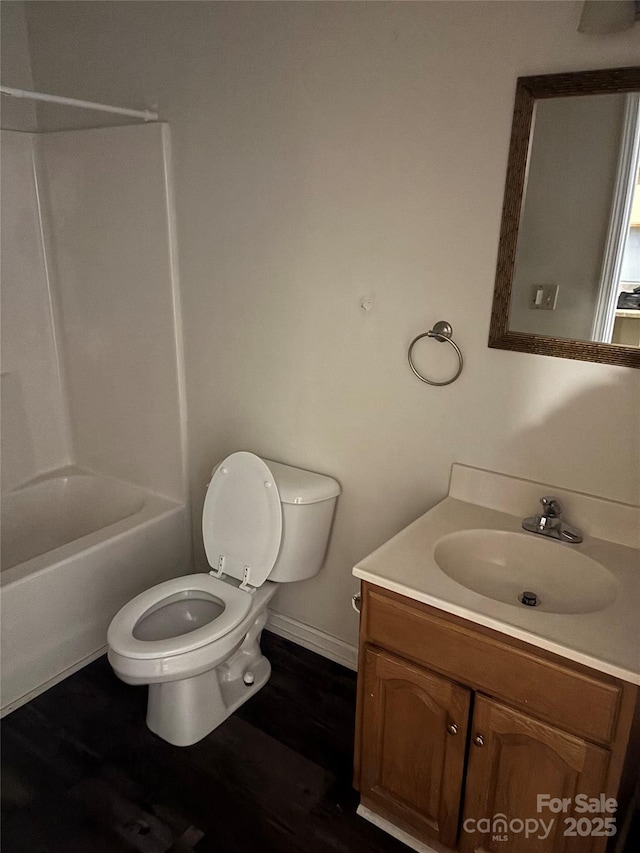 full bathroom featuring hardwood / wood-style flooring, tub / shower combination, toilet, and vanity