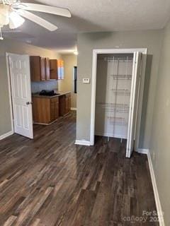 interior space with dark wood-type flooring and ceiling fan