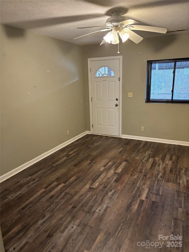 entrance foyer with ceiling fan, a textured ceiling, and dark hardwood / wood-style flooring