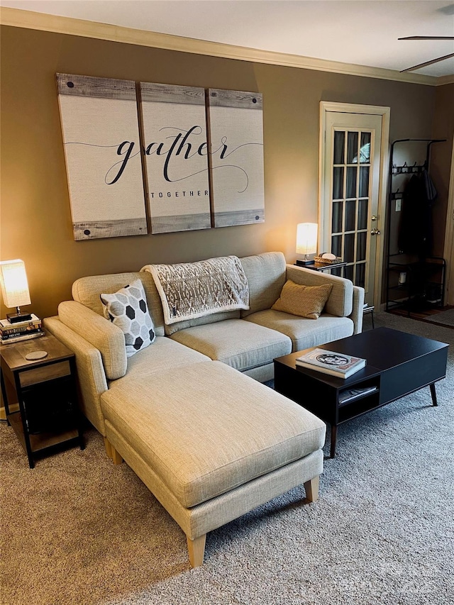 carpeted living room with ceiling fan and crown molding