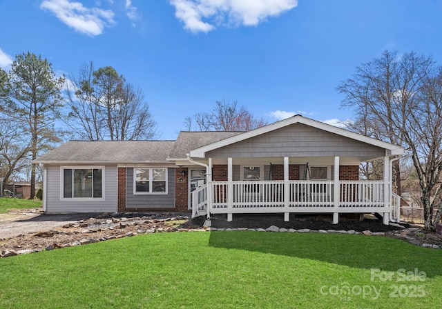 ranch-style house featuring covered porch and a front lawn