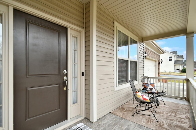 entrance to property featuring a garage and a porch