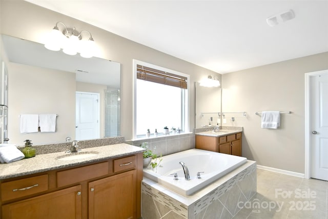 bathroom with vanity, tile patterned floors, and tiled bath