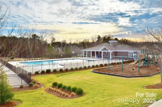 pool at dusk with a yard and a playground