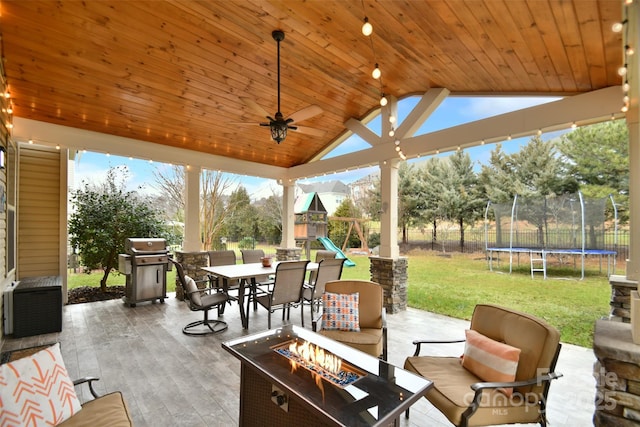 view of patio / terrace featuring a trampoline, a fire pit, area for grilling, and a playground