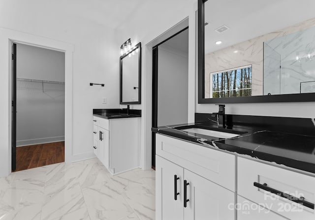 bathroom featuring a tile shower and vanity