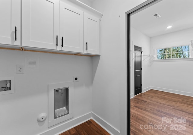 washroom with hookup for a gas dryer, hardwood / wood-style flooring, hookup for a washing machine, and cabinets