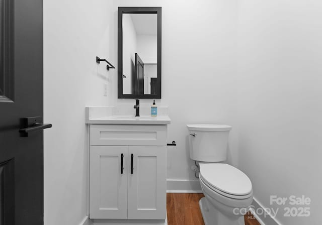 bathroom featuring toilet, vanity, and wood-type flooring