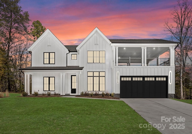 view of front of home with a balcony, a garage, and a lawn