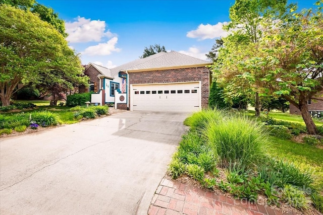 single story home featuring driveway, brick siding, and a garage