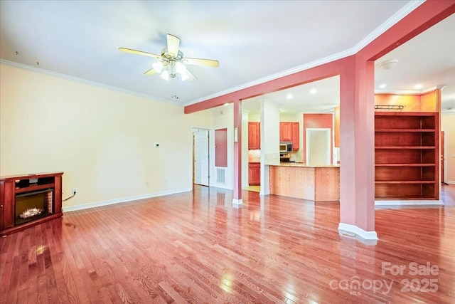 unfurnished living room featuring light wood finished floors, a ceiling fan, baseboards, and ornamental molding