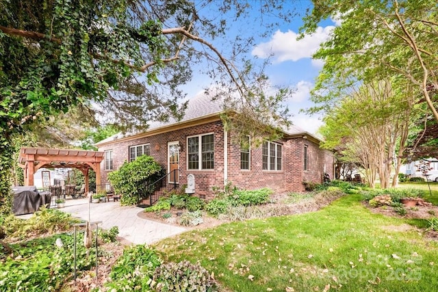 view of front of property featuring a pergola, a patio area, brick siding, and a front lawn