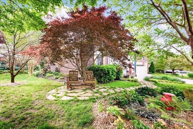 view of yard with an attached garage and driveway