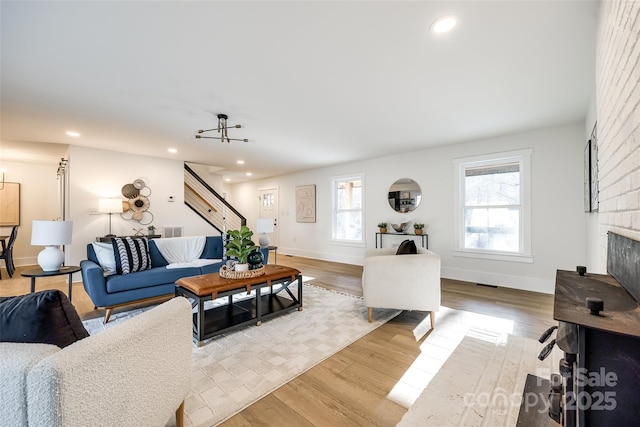 living room featuring a fireplace, plenty of natural light, and light wood-type flooring